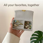 Grey jewelry box in hand with rings, earrings and bracelet inside