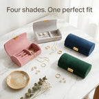 Four jewelry boxes on a marble vanity with gold jewelry